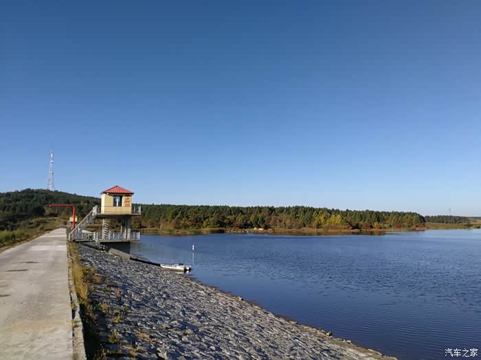 途径吉林省吉林市磐石市,一个水库,在朝阳下碧空,绿树,蔚蓝水.