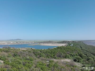 面有俄羅斯哈桑鎮處山藍色日本海湖泊旁邊白色建築我國哨塔塔有土字牌