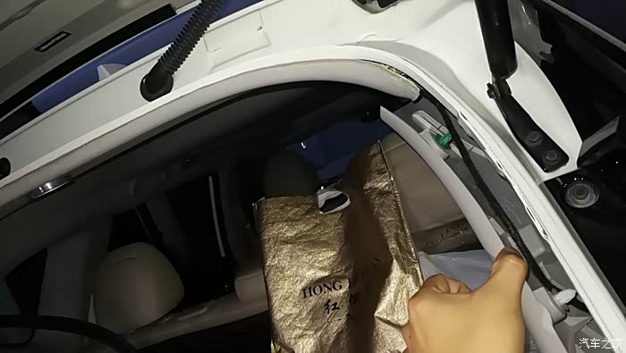 用手扒开尾门右侧胶条,用撬棒撬开后备箱右侧卡扣.