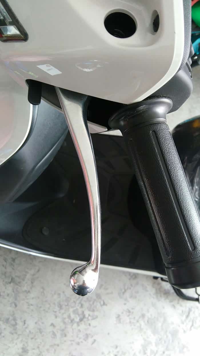 看到刹车手柄前面黑铁片么,把捏住刹车  把它往抬就行,(驻车手刹)