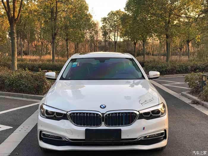 停在树荫下的领先型宝马5,这样白色的新能源汽车,内饰真豪华.