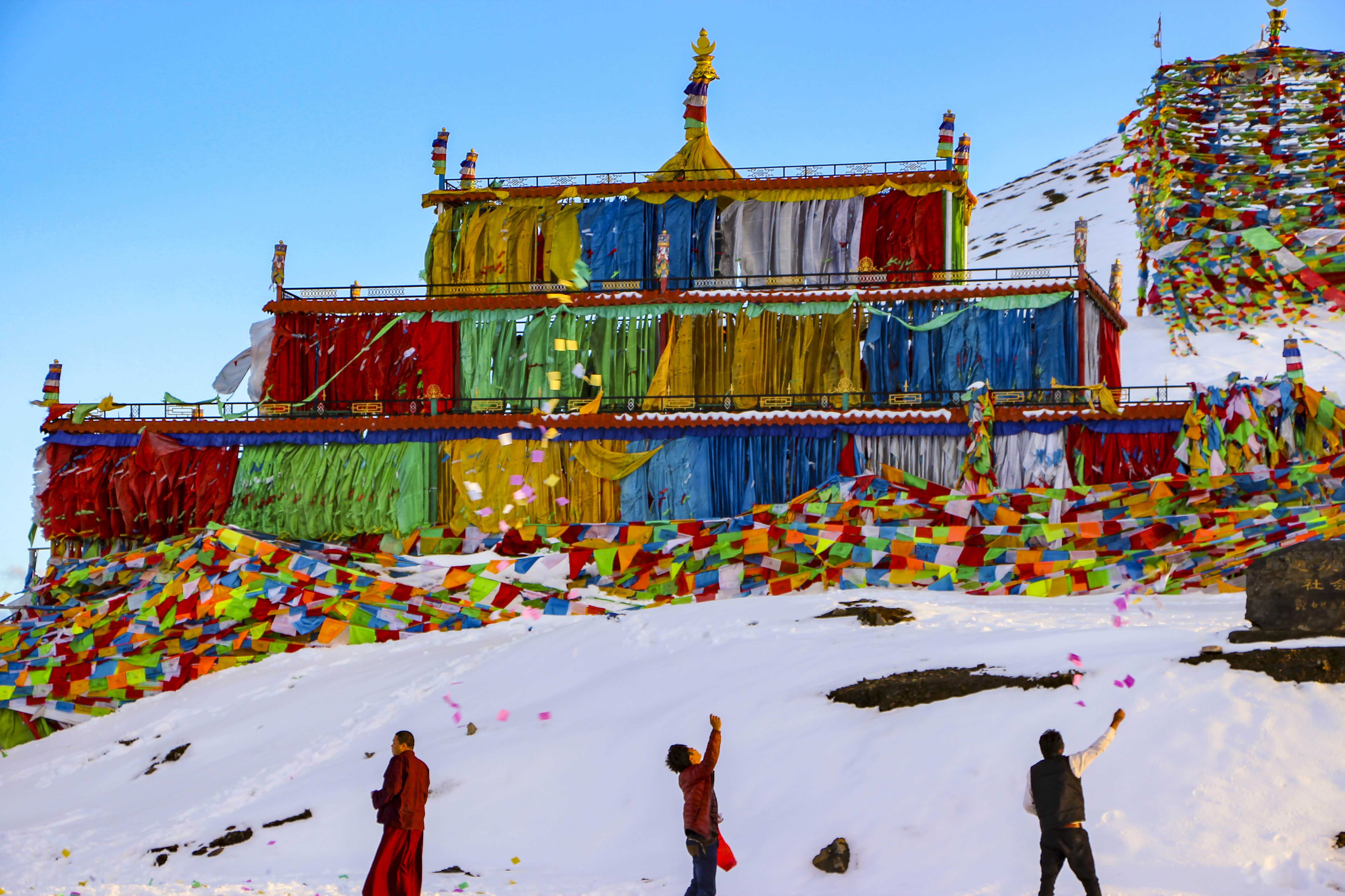 人们掏出把把的风马向空中抛撒.风马随风翩翩起舞