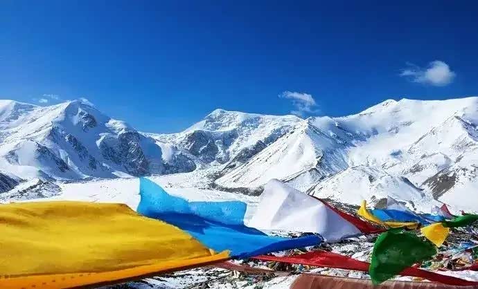雪山的前面,布满了五彩经幡,穿过舞动的经幡,可以到达雪山脚下