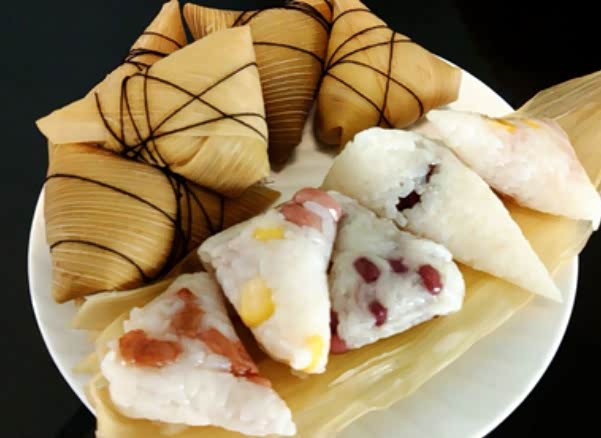 粽子,又称"角黍","筒粽",由粽叶包裹糯米蒸制而成