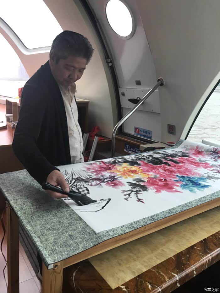 挥毫作画的艺术家何甲荣.