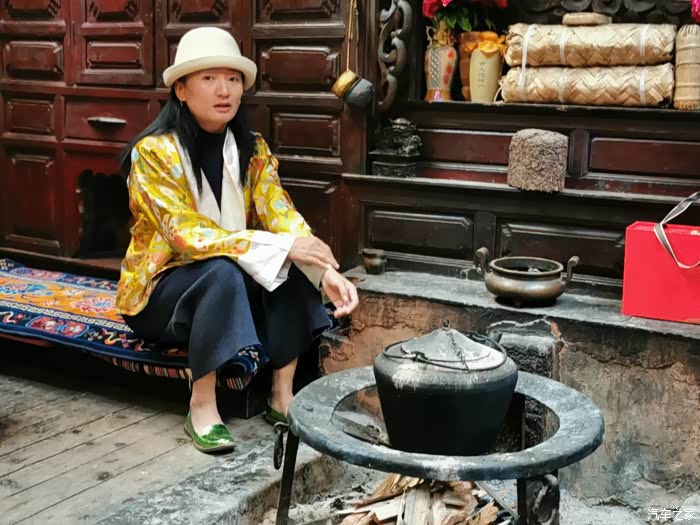 一家人围火塘而坐,老祖母拾材添火,这也许就是母系氏族文化下的摩梭