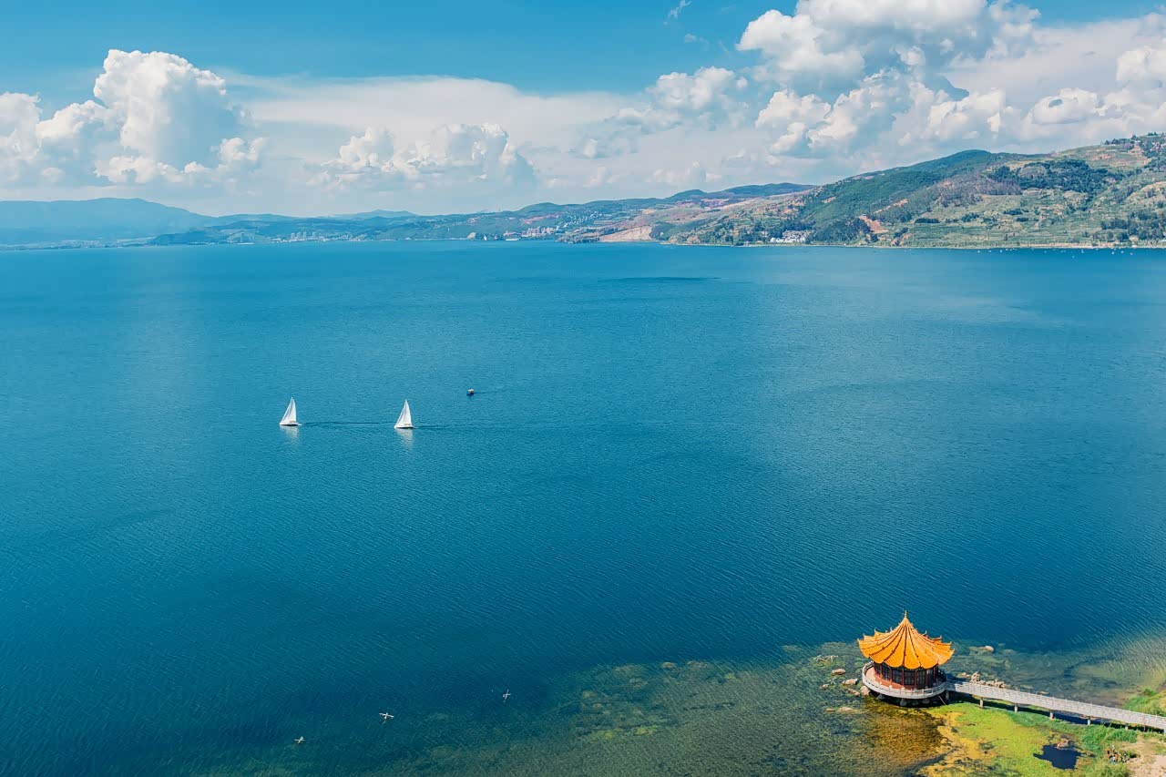 湖水像一块无限的翡翠闪烁着美丽的光泽.清风吹拂蔚蓝色的湖面.