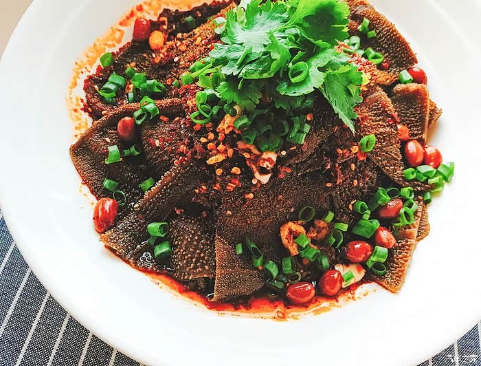 6,调好的汁水淋在摆好的毛肚上,均匀的撒上油酥花生,葱花,香菜摆中间