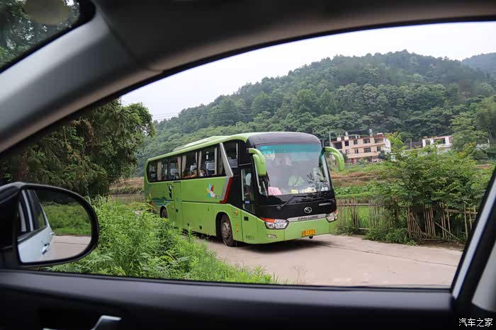 城市里的旅游大巴,也开进了乡村里,村里道路狭窄,会车还得开到岔路上