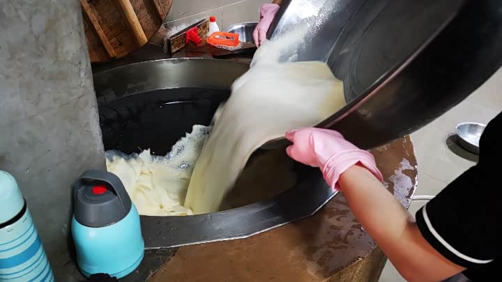 豆腐坊的人把过滤好的豆浆到进大铁锅里,果然是最原始的工艺.