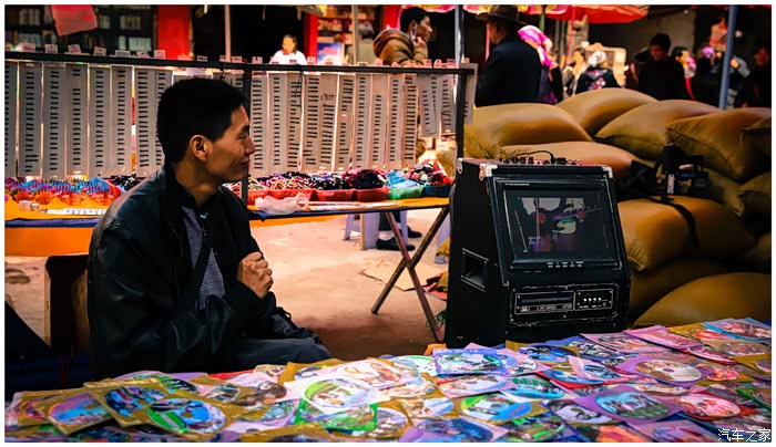 集市上,一位商贩在卖他们的民族光盘,里面是他们的民族舞蹈.