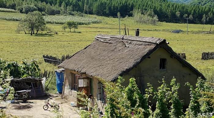 流行的民房,草房,这个年代并不久远,看到有摩托车,小轮自行车.