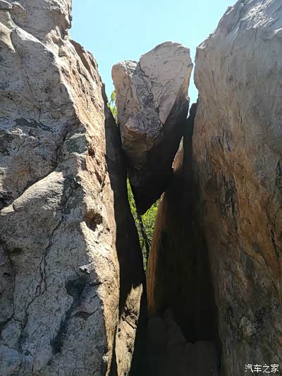 前方到达一个石缝处,上方悬着一块大石头,驴友要从石缝中钻过去.